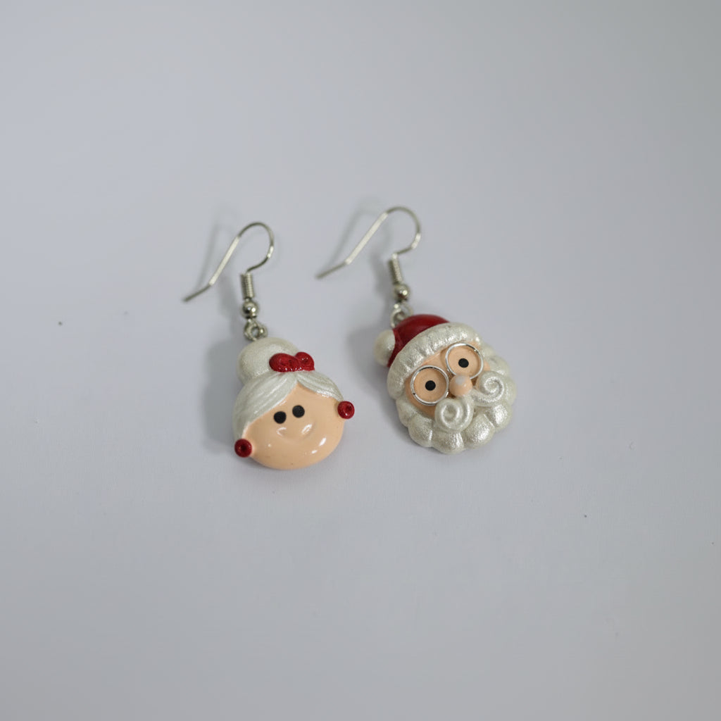 Pair of earrings with Santa Claus design on a light gray background with yellow flowers.